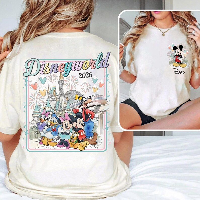 Pu&ograve; includere: T-shirt color crema con una grafica colorata di Disney World 2026 sul retro con personaggi dei cartoni animati. La parte anteriore presenta una grafica pi&ugrave; piccola di Mickey Mouse con la scritta "Dad" sotto. La maglietta ha maniche corte.