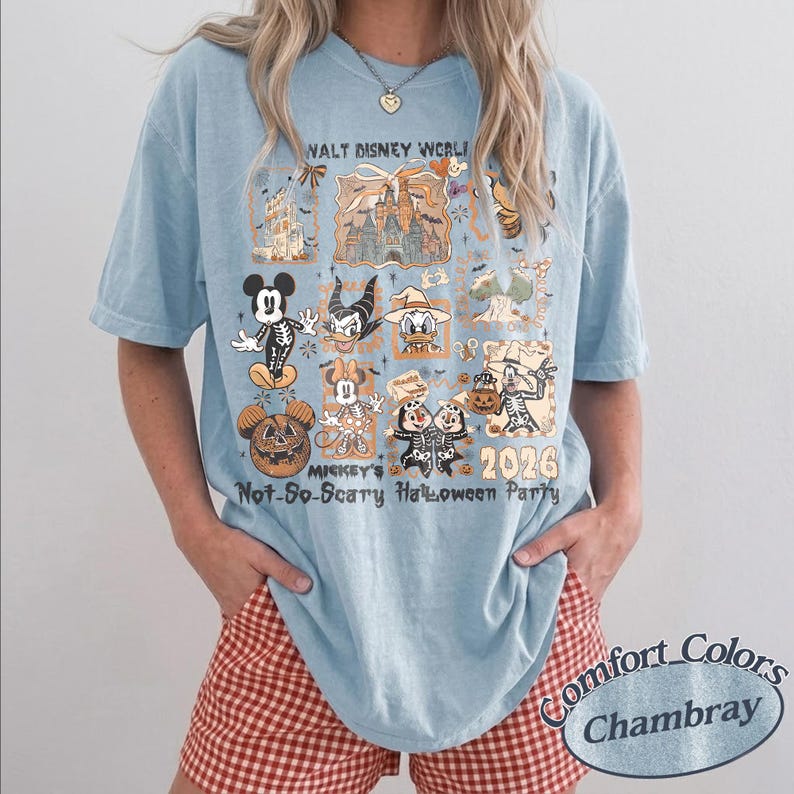 Pu&ograve; includere: T-shirt Comfort Colors Chambray azzurra con grafica per Mickey's Not-So-Scary Halloween Party 2026 a Walt Disney World. Il design include vari personaggi Disney in costume di Halloween.
