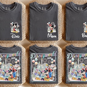 Pu&ograve; includere: Sei magliette grigio scuro con disegni a tema Disney. Tre magliette presentano Topolino, Minnie e Pluto con le parole "Dad", "Mom" e "Brother". Le altre tre magliette hanno una grafica "Disneyworld 2026" con personaggi Disney.