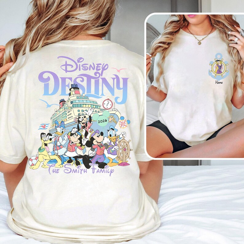 May include: Cream-colored t-shirt featuring a Disney cruise design. The back displays "Disney Destiny" with a cruise ship graphic and Disney characters. The front has an anchor design with a character and space for a name.
