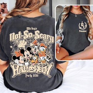 May include: Dark gray t-shirt featuring a Halloween design with Mickey Mouse, Minnie Mouse, Goofy, Donald Duck, and Pluto. The shirt has the text "Mickey's Not-So-Scary Halloween Party 2026" in a stylized font. A smaller image on the front shows a Mickey Mouse head.