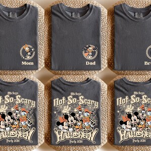 May include: Six dark gray t-shirts with Halloween-themed designs. Three shirts have character graphics with "Mom", "Dad", and "Brother" labels. The other three shirts feature a graphic of Mickey Mouse and friends with "Mickey's Not-So-Scary Halloween Party 2020" text.