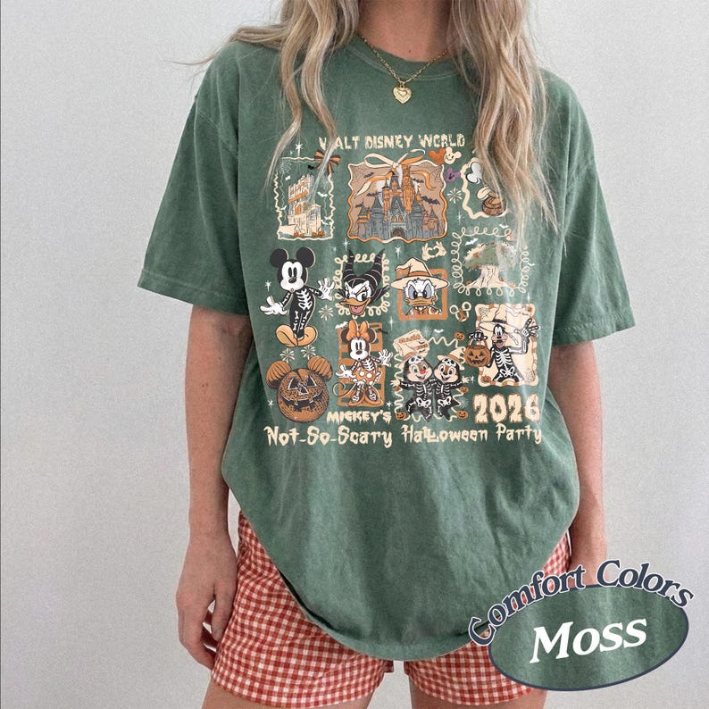 Pu&ograve; includere: T-shirt verde con grafica di personaggi Disney in costume di Halloween, la scritta "Walt Disney World" e "Mickey's Not-So-Scary Halloween Party 2026." La maglietta &egrave; color Comfort Colors Moss.
