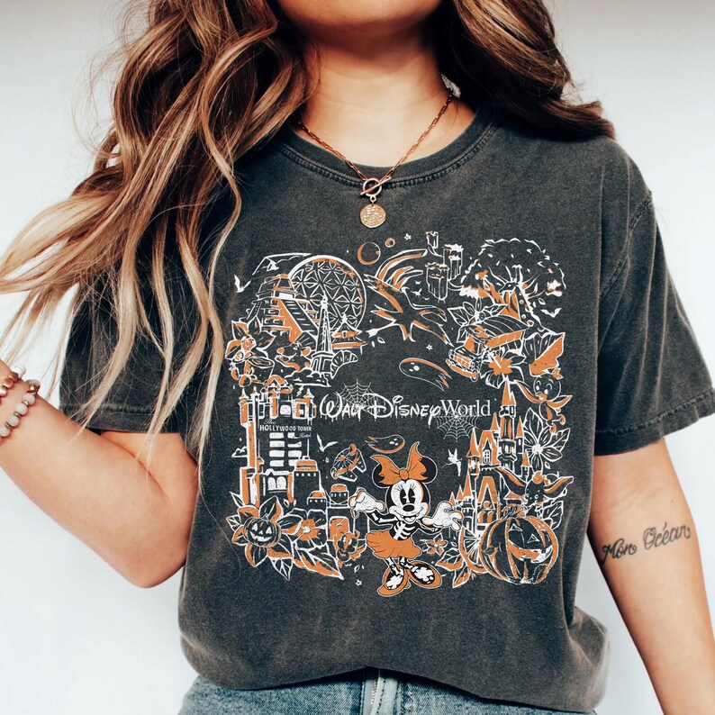 May include: A dark gray t-shirt with a white graphic print of Mickey Mouse and various Halloween-themed Disney World attractions. The text "Walt Disney World" is printed on the shirt.