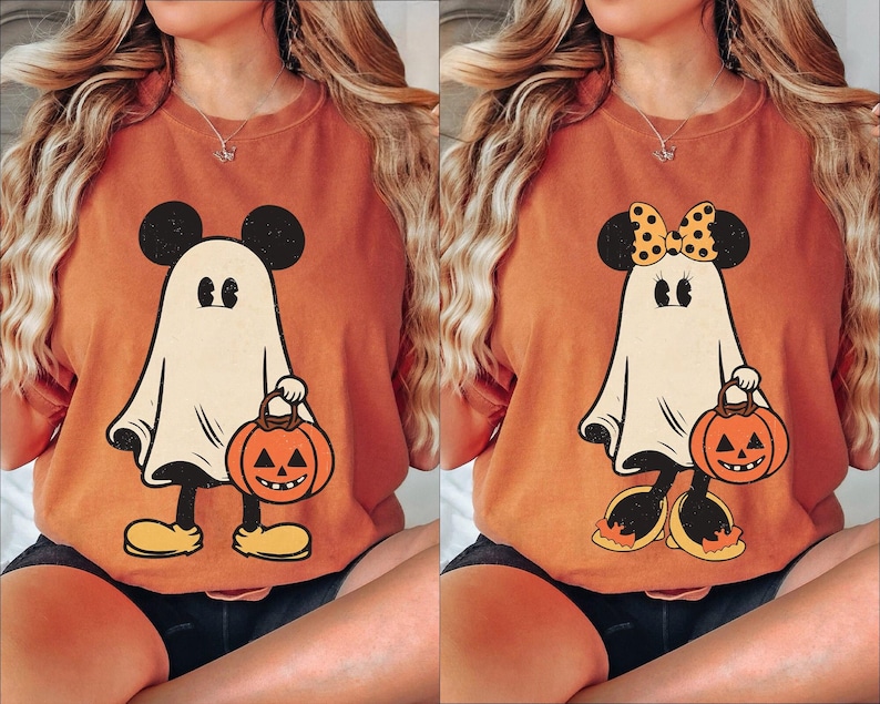 May include: Two orange Halloween themed t-shirts with a ghost Mickey Mouse design. One shirt has a black and white polka dot bow on the ghost's head. Both ghosts are holding a jack-o-lantern.