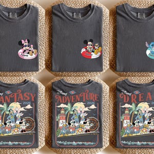 May include: Six dark grey t-shirts with Disney character graphics. Three shirts feature Mickey and Minnie Mouse or Stitch in inner tubes. The other three shirts have a vintage travel poster design with Mickey and friends, the words "FANTASY", "ADVENTURE", and "DREAM", and the year 2026.