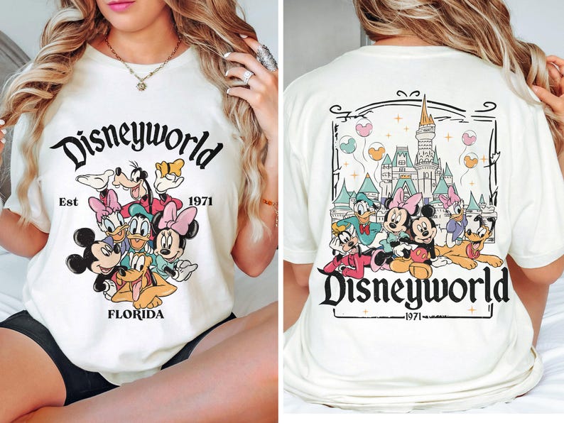 Puede incluir: Camiseta blanca con un gr&aacute;fico colorido de Mickey Mouse y sus amigos frente al Castillo de Cenicienta. El texto "Disneyworld Est 1971 Florida" est&aacute; impreso en la camiseta.