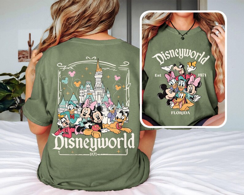 Puede incluir: Camiseta verde con un gr&aacute;fico de Mickey Mouse y sus amigos frente al Castillo de Cenicienta. El texto "Disneyworld Est. 1971 Florida" est&aacute; impreso en la camiseta.