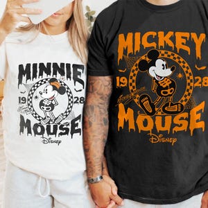 May include: Two t-shirts, one white and one black, featuring Disney's Minnie and Mickey Mouse in a Halloween skeleton design. The shirts have the text "Minnie Mouse" and "Mickey Mouse" with the year "1928" and the Disney logo.