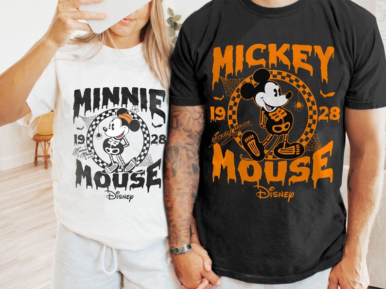 May include: Two t-shirts, one white and one black, featuring Disney's Minnie and Mickey Mouse in a Halloween skeleton design. The shirts have the text "Minnie Mouse" and "Mickey Mouse" with the year "1928" and the Disney logo.
