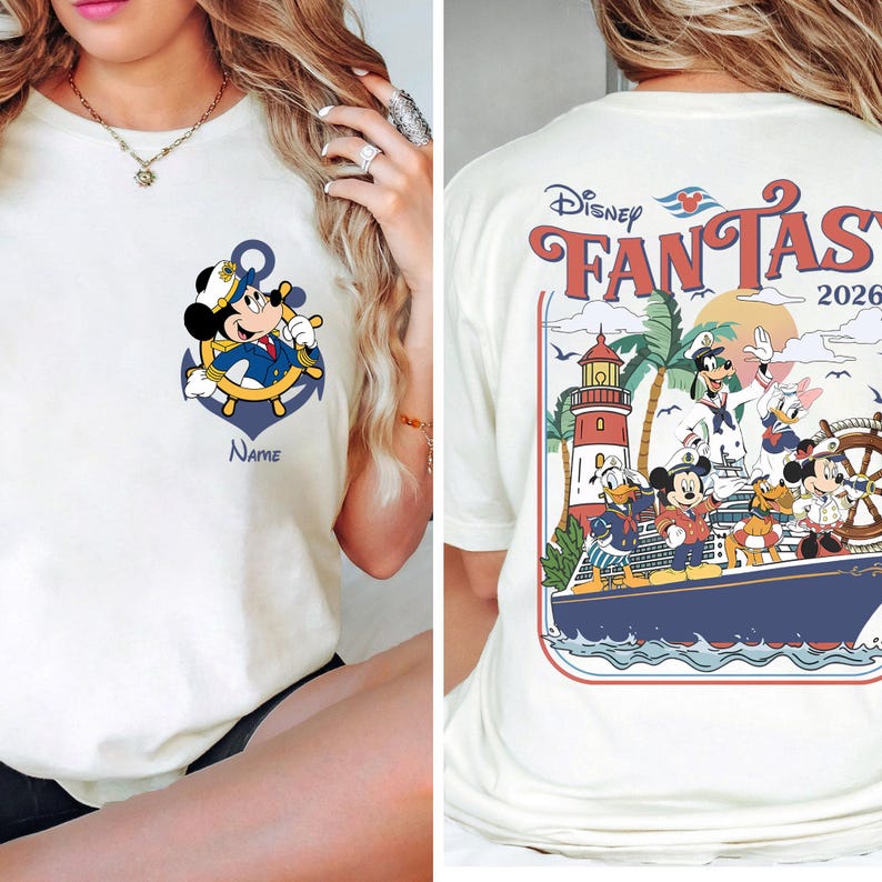 May include: Cream-colored t-shirt featuring a cartoon Mickey Mouse as a ship captain, with an anchor and the word "Name" below. The back of the shirt displays "Disney Fantasy 2026" with various Disney characters on a cruise ship.