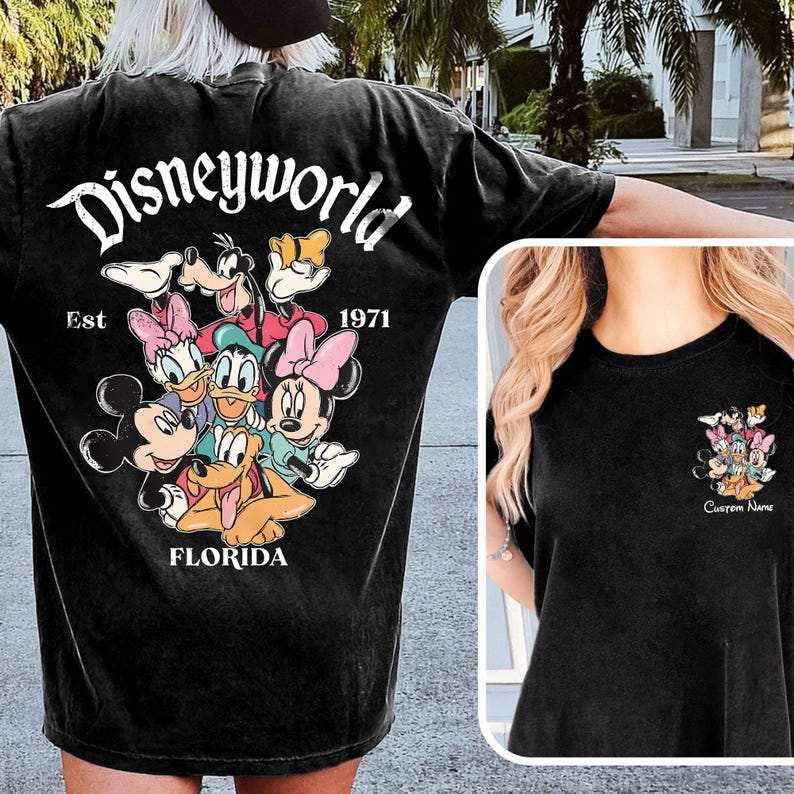 May include: Black t-shirt featuring a Disney World graphic with Mickey Mouse, Minnie Mouse, Donald Duck, Daisy Duck, Goofy, and Pluto. The text "Disneyworld Est 1971 Florida" is also printed on the shirt.