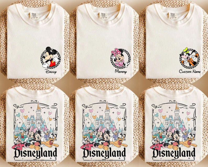 May include: Off-white t-shirts with Disney character graphics. Some shirts feature Mickey Mouse, Minnie Mouse, and Goofy in circular designs with text like "Daddy," "Mommy," and "Custom Name." Other shirts display a Disneyland graphic.