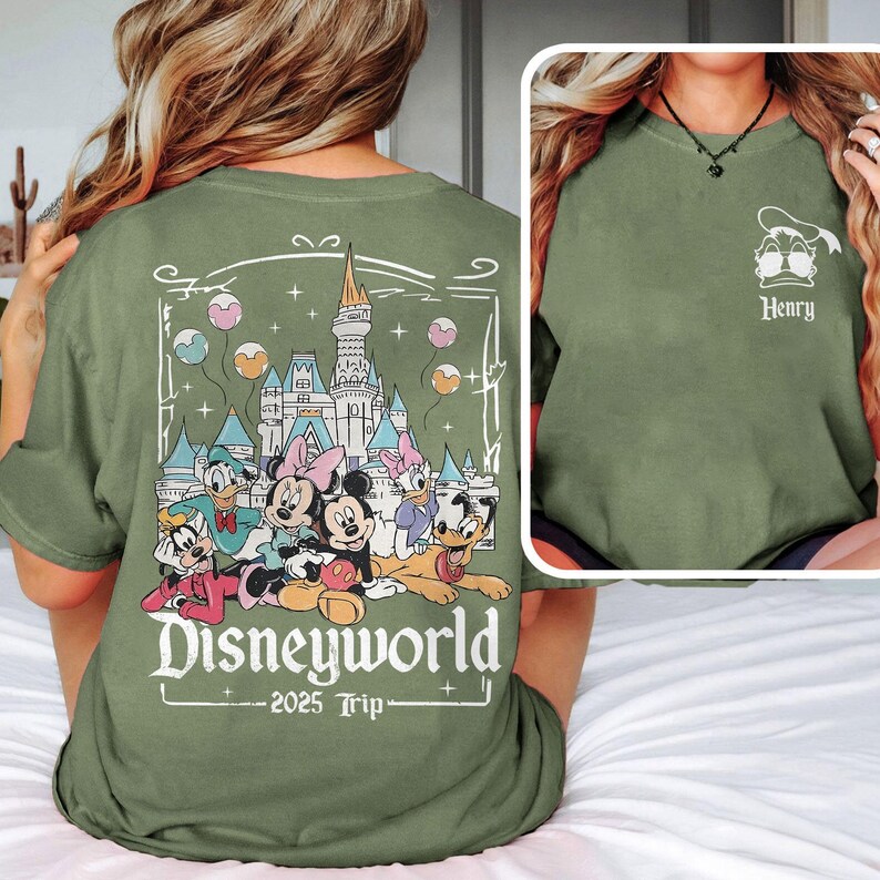May include: Green t-shirt with a graphic of Mickey Mouse and friends in front of Cinderella's Castle. The text "Disneyworld 2025 Trip" is printed below the graphic.
