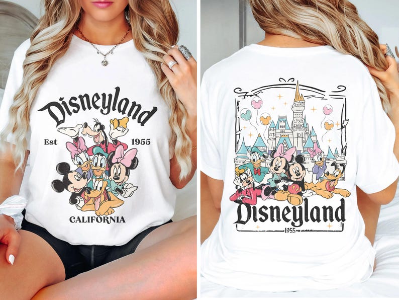 May include: White t-shirt with a graphic print of Mickey Mouse and friends in front of Disneyland. The text "Disneyland Est 1955 California" is printed on the front of the shirt. The back of the shirt features a graphic print of Disneyland castle and Mickey Mouse and friends. The text "Disneyland 1955" is printed on the back of the shirt.