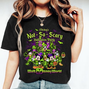 May include: Black t-shirt featuring a Halloween design with Mickey Mouse, Minnie Mouse, Donald Duck, Goofy, and Pluto in skeleton costumes. The shirt reads "Mickey's Not-So-Scary Halloween Party" with the Walt Disney World logo.