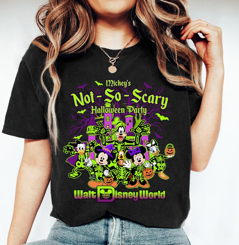 May include: Black t-shirt featuring a Halloween design with Mickey Mouse, Minnie Mouse, Donald Duck, Goofy, and Pluto in skeleton costumes. The shirt reads "Mickey's Not-So-Scary Halloween Party" with the Walt Disney World logo.