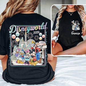 Pu&ograve; includere: T-shirt nera con una grafica colorata di Disney World 2026 sul retro, con Topolino, Minnie, Paperino, Paperina, Pippo e Pluto. Una grafica pi&ugrave; piccola sulla tasca anteriore dice "Grandpa".