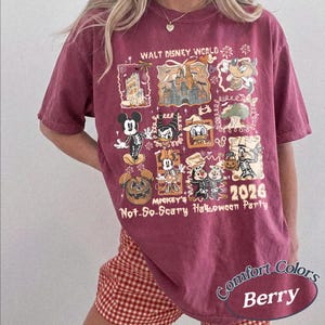 Pu&ograve; includere: T-shirt color bacca con un design grafico di personaggi Disney in costume di Halloween. La maglietta include il testo "WALT DISNEY WORLD", "MICKEY'S Not-So-Scary Halloween Party" e l'anno "2026". La maglietta &egrave; etichettata "Comfort Colors Berry".