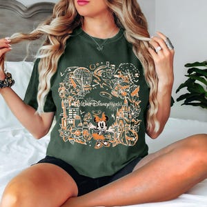 May include: A green t-shirt with a graphic print of Mickey Mouse and other Disney characters. The graphic includes the text "Go... Walt Disney World".
