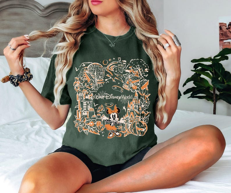 May include: A green t-shirt with a graphic print of Mickey Mouse and other Disney characters. The graphic includes the text "Go... Walt Disney World".