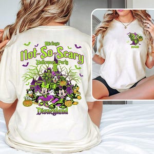May include: Cream-colored t-shirt featuring a Halloween-themed graphic. The design includes the text "Mickey's Not-So-Scary Halloween Party Disneyland" in green and purple, along with images of Disney characters in Halloween costumes.