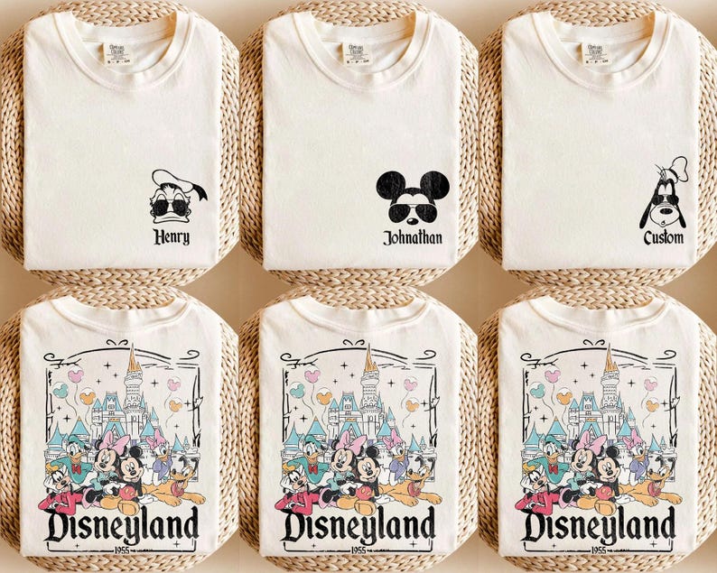 K&ouml;nnte beinhalten: Sechs wei&szlig;e T-Shirts mit verschiedenen Designs. Drei Shirts zeigen eine Comicfigur: Donald Duck, Mickey Mouse und Goofy. Die anderen drei Shirts zeigen ein Comicbild von Disneyland mit dem Text "Disneyland 1955".