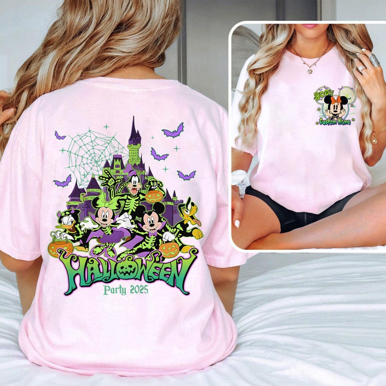Op de afbeelding: Lichtroze t-shirt met een Halloween-ontwerp. Het ontwerp toont Disney-figuren, een spookkasteel en vleermuizen. Het woord "Halloween" is groen, met de tekst "Party 2025".