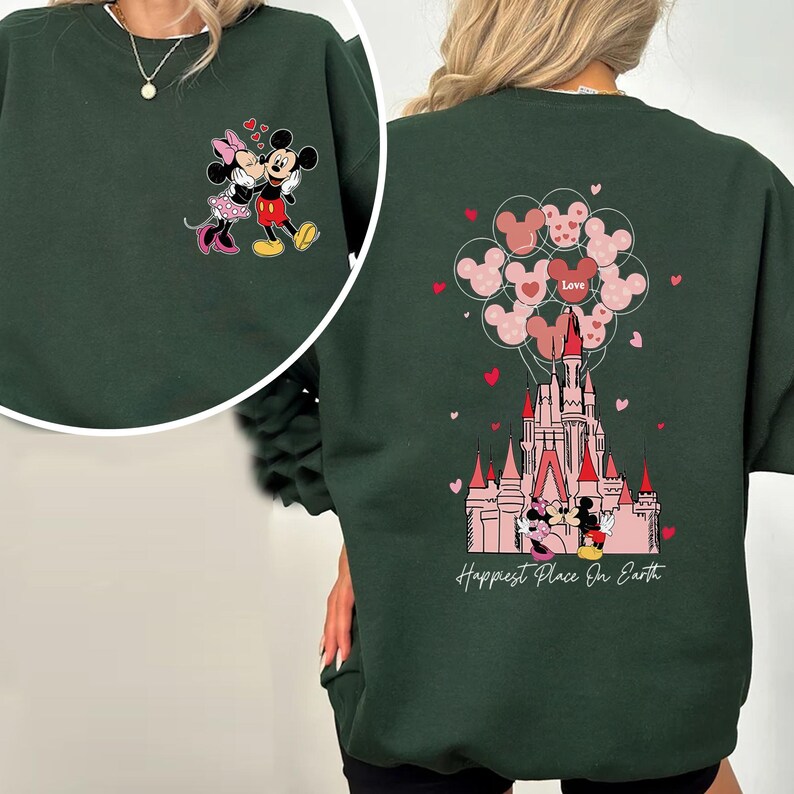 May include: Dark green sweatshirt featuring Mickey and Minnie Mouse. The front has a small image of the couple, while the back showcases a castle with heart-shaped balloons and the text "Happiest Place On Earth."