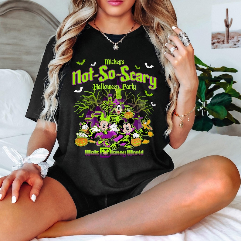 Pu&ograve; includere: Maglietta nera con una grafica verde e viola di Topolino e i suoi amici vestiti con costumi di Halloween. Il testo "Mickey's Not-So-Scary Halloween Party" e "Walt Disney World" sono stampati sulla maglietta.