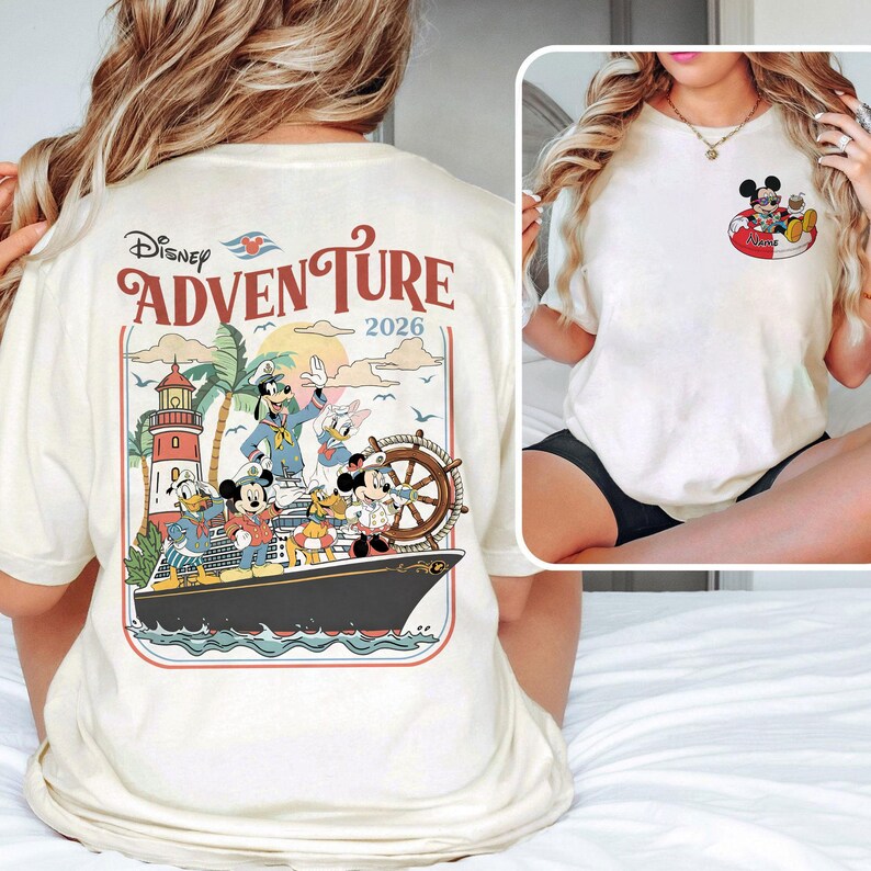May include: Cream-coloured t-shirt with a Disney Adventure graphic. The design features Mickey Mouse, Donald Duck, Goofy, and Daisy Duck on a cruise ship, with a lighthouse and palm trees. The text "Disney Adventure 2026" is also visible.
