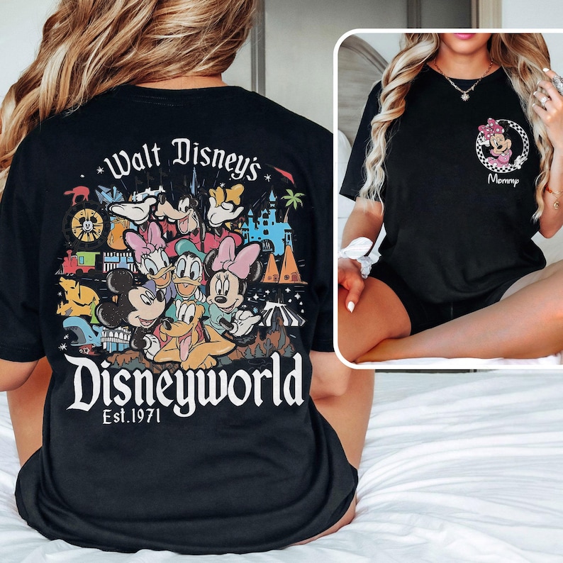 May include: Black t-shirt featuring a colorful Disney World graphic on the back with Mickey, Minnie, Donald, and Goofy. The front of the shirt has a Minnie Mouse design with the word "Mommy".