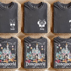 May include: Three gray t-shirts with different designs. The first shirt has a white outline of a character with sunglasses and the text "Jennifer". The second shirt has a white outline of a character with sunglasses and the text "Jenny". The third shirt has a white outline of a character with ears and the text "Custom". The bottom three shirts have a black and white illustration of a castle and characters with the text "Disneyworld - 2025 Trip".