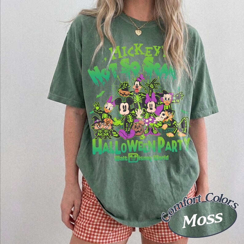 Op de afbeelding: Mosgroen T-shirt met een Halloween-afbeelding met Disney-personages. Het ontwerp bevat de tekst "Mickey's Not-So-Scary Halloween Party" en "Halloween Party" met het Walt Disney World-logo. Het shirt is van het merk Comfort Colors.