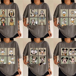 May include: Six grey t-shirts, each with a grid of cartoon characters in safari outfits. The characters include Pluto, Goofy, Donald Duck, Daisy Duck, Minnie Mouse, and Mickey Mouse. The shirts are short-sleeved.