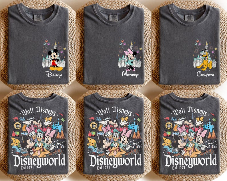 May include: Six dark gray t-shirts with Disney character designs. Three shirts feature Mickey, Minnie, and Pluto with text like "Daddy", "Mommy", and "Custom". The other three shirts display a colorful Disney World graphic with "Walt Disney's Disneyworld Est. 1971".