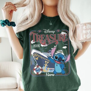 May include: Dark green t-shirt featuring a Disney Treasure cruise design. The graphic includes a cruise ship, the character Stitch, and the text "Disney Treasure 2026". The design is framed in a retro style.