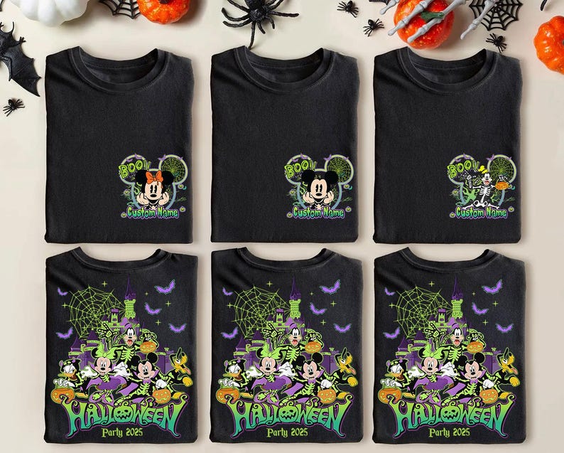 Op de afbeelding: Zwarte T-shirts met Halloween-ontwerpen. De shirts hebben Mickey en Minnie Mouse met de tekst "Boo" en "Custom Name". Andere shirts hebben een Halloween-feestontwerp met de tekst "Halloween Party 2025".