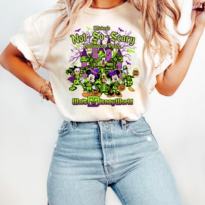 May include: Cream-colored t-shirt featuring a Halloween-themed graphic. The design includes Disney characters dressed in skeleton costumes, a haunted castle, and the text "Mickey's Not-So-Scary Halloween Party" and "Walt Disney World".