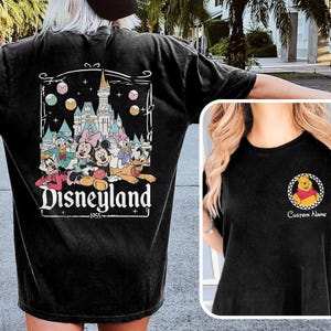 May include: Black t-shirt featuring a Disneyland graphic on the back with Mickey Mouse, Minnie Mouse, Donald Duck, and other characters. The front has a small Winnie the Pooh design with the text "Custom Name".