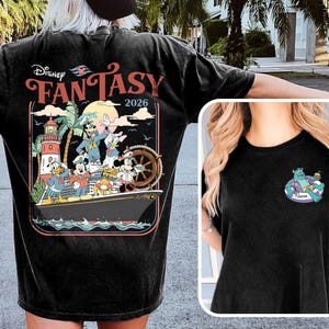 May include: Black t-shirt with a vibrant graphic of Disney characters on a cruise ship, including the text "Disney Fantasy 2026." The shirt also features a small cartoon character graphic on the front.