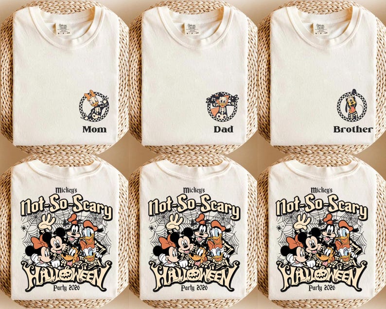 May include: Off-white t-shirts with Halloween-themed graphics. Some shirts have character designs with the words "Mom", "Dad", and "Brother". Other shirts feature Mickey Mouse and friends with the text "Mickey's Not-So-Scary Halloween Party 2026".