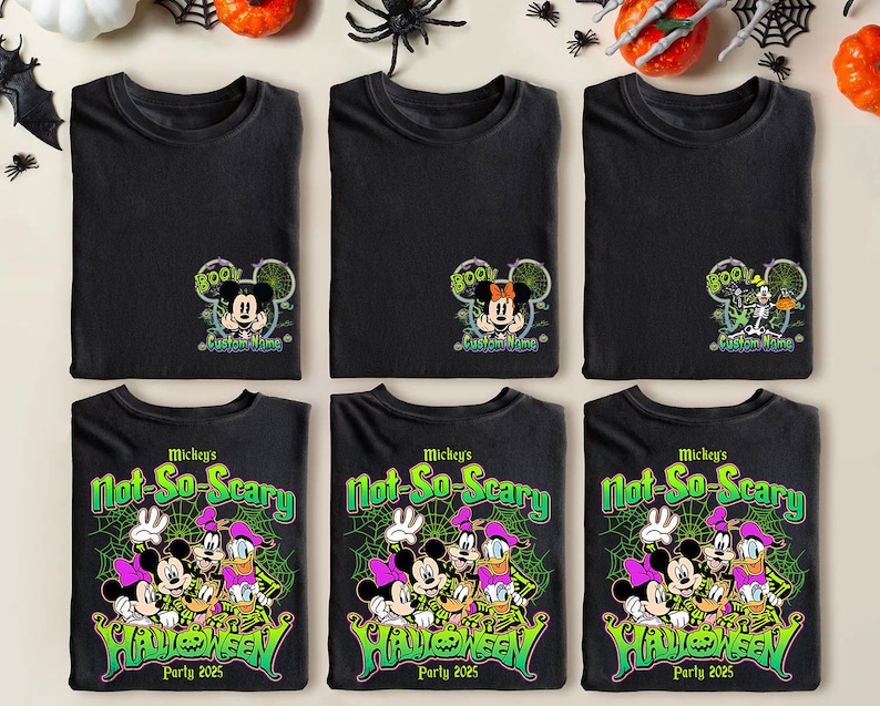 Op de afbeelding: Zwarte t-shirts met Halloween-ontwerpen. De bovenste rij toont Mickey en Minnie Mouse met "BOO!" en "Custom Name". De onderste rij toont Mickey, Minnie, Donald en Daisy Duck met "Mickey's Not-So-Scary Halloween Party 2025".
