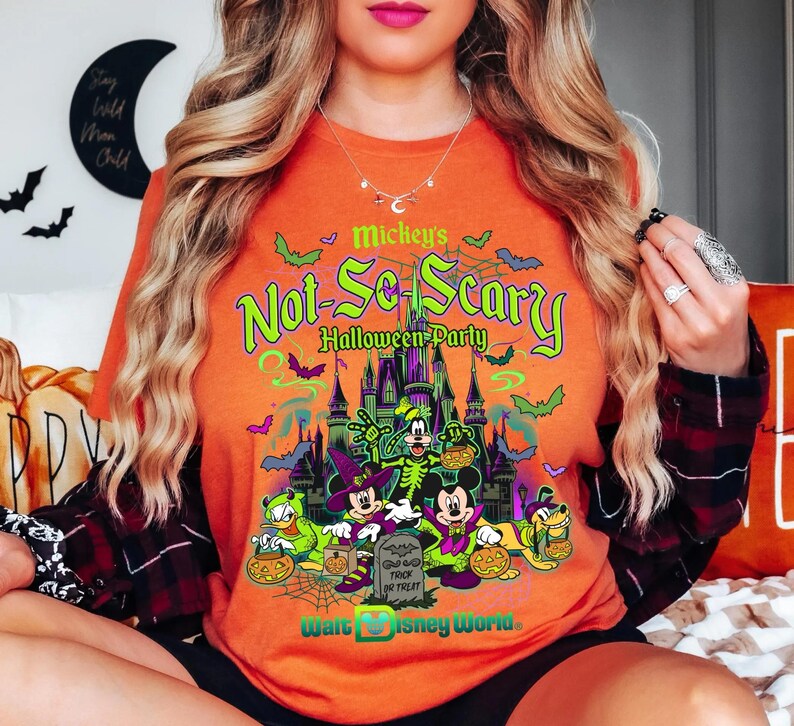 May include: Orange t-shirt with a Halloween-themed design. The shirt features Mickey Mouse and friends, the text "Mickey's Not-So-Scary Halloween Party", and "Walt Disney World", with bats and a spooky castle.