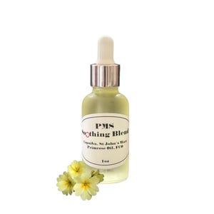 May include: A clear glass bottle with a gold cap and dropper, labeled "PMS Soothing Blend Copaiba, St. John's Wort Primrose Oil, FCO 1 oz.". The bottle is sitting on a white background with a cluster of yellow primrose flowers.