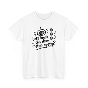 May include: A white short-sleeved t-shirt featuring a black graphic of a smiling robot head and the text Let's break this down step-by-step, accompanied by a vertical list of numbers one, two, and three with curved arrows.