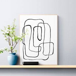 Puede incluir: Impresión de arte abstracto en blanco y negro en un marco blanco. La impresión presenta una serie de círculos y óvalos superpuestos.