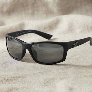 May include: Matte black sunglasses featuring a rectangular frame design with dark grey polarised lenses. The temples display the Maui Jim logo in a silver script font, and the frame has a smooth, non-reflective finish across the entire structure.