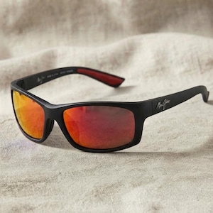 May include: Matte black sunglasses featuring rectangular frames and reflective orange-red lenses. The temples display the Maui Jim logo in white lettering, while the interior of the temple tips is lined with a contrasting dark red material.