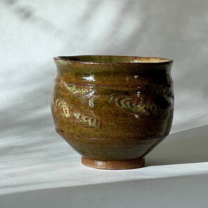 Textured green wheel thrown stoneware ceramic pottery tea and coffee cup.